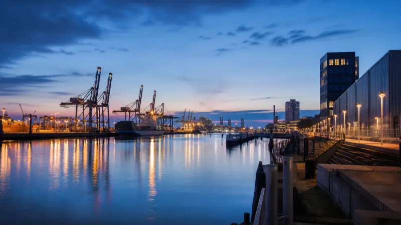 Bremer Hafen mit Containerkränen und Logistikinfrastruktur in der blauen Stunde